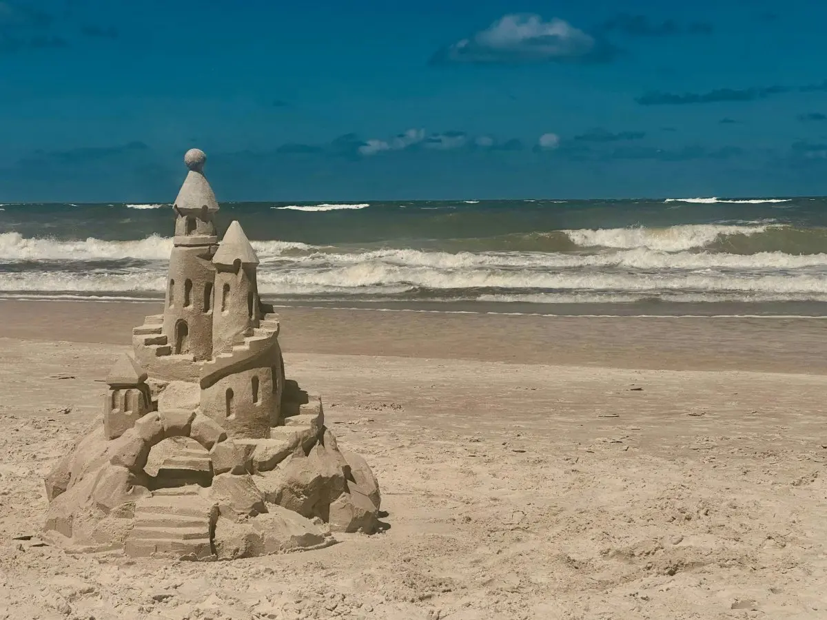 Travail au père Un magnifique chateau de sable devant une mer calme, illustrant la nouvelle Travail au père d'Eléa Valenti