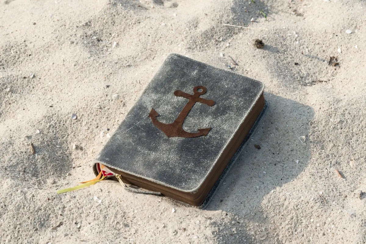 Livre en partie enlisé dans le sable, indiquant le processus d'écriture du recueil Cent nouvelles de la plage